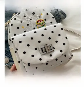 Détail du mini sac à pois avec broderie de burger et fermoir rotatif en métal
