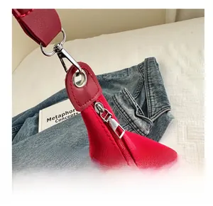 Detail of red canvas tote bag with leather loops, silver D-ring and smooth metal zipper