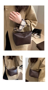 Close-up of dark brown woven leather bucket bag with silver hardware and fine texture