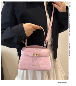 Détail macro du sac à main rose en cuir gaufré crocodile avec fermoir doré chic