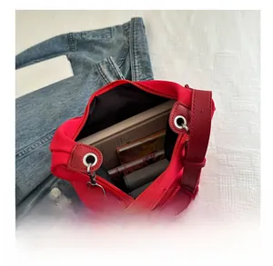 Interior view of large red canvas tote bag showing books and a wallet for storage capacity
