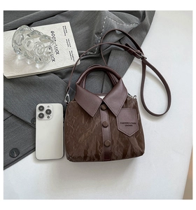 Détail macro du sac bandoulière marron foncé en forme de chemise avec boutons et sangle