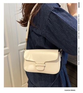 Detail view of a cream crossbody bag with gold chain and matching leather shoulder strap