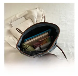 Detailed internal view showing large capacity for umbrella, tablet, and books in tote bag