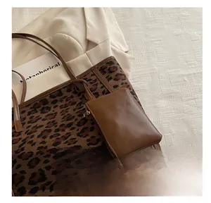 Dettaglio della borsa tote leopardata con accessorio in pelle marrone su tessuto