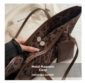 Dettaglio della borsa tote leopardata vintage con chiusura a fibbia magnetica metallica
