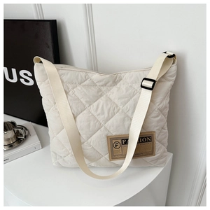 Détail du sac bandoulière matelassé beige avec surpiqûres losanges et sangle réglable