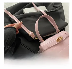 Détail du sac rose texture crocodile avec boucle en métal doré réglable de qualité