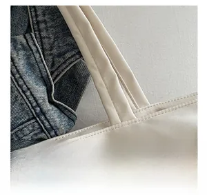 Close-up of durable shoulder strap stitching on a white canvas tote bag for work