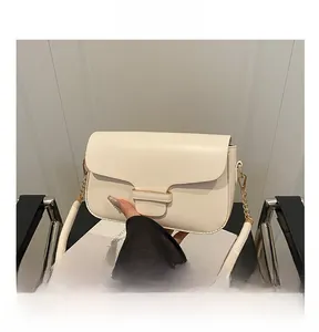Detail of cream leather handbag with gold chain strap and elegant fixed top handle
