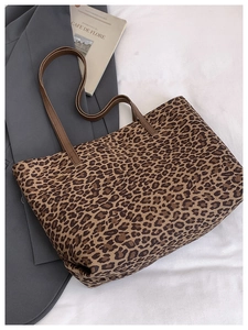 Detailed view of large leopard print tote bag on grey blazer for daily commute fashion