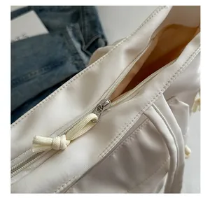 Detailed close-up of nylon tote bag zipper with decorative woven knot puller