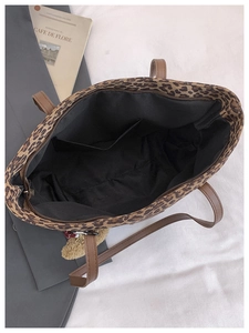 Detailed top view of leopard print tote bag with brown straps and spacious black interior