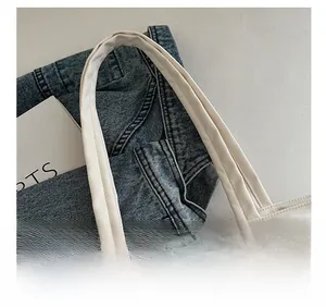Detail of comfortable wide shoulder strap on off-white Oxford fabric tote bag