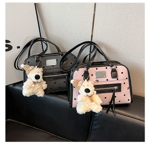 Detail view of pink and grey polka dot tote bags with ribbon and bear keychain on sofa