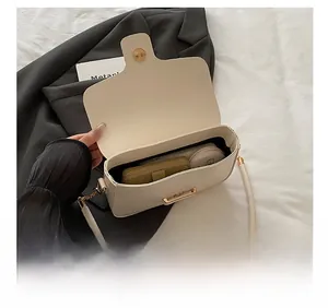 Detail showing the internal capacity of the cream leather crossbody bag with chain strap