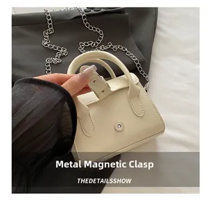 Detail shot of mini leather bag showing the silver magnetic snap closure mechanism