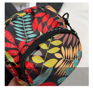 Detail of floral canvas crossbody bag with colorful leaf print and sturdy black zipper closure