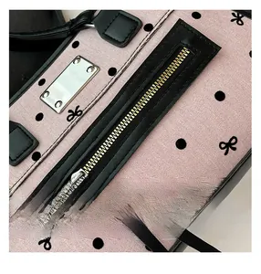 Detailed close-up of pink polka dot and bow pattern fabric with premium metal zipper