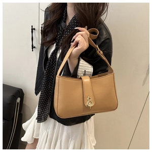 Detail of khaki leather shoulder bag featuring a unique gold metal buckle and smooth finish