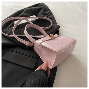 Détail du sac à main rose motif crocodile avec fermoir doré et bandoulière réglable