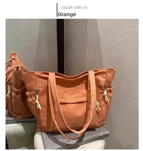 Detail of orange nylon dumpling bag showing functional pockets and cotton rope zip pulls