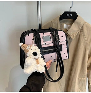 Detail of pink polka dot bag with black leather straps and a cute plush bear charm