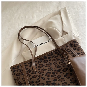 Detail of leopard print tote bag with brown leather straps and matching mini pouch