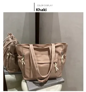 Detail of khaki large capacity tote bag with functional pockets and white drawstring cord