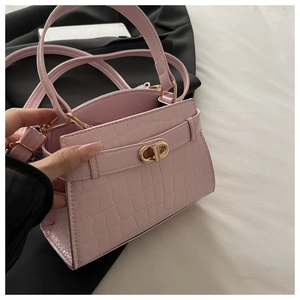 Détail du sac à main rose gaufré crocodile avec fermoir doré et bandoulière fine