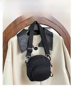 Detail of black waterproof nylon crossbody bag with adjustable strap and front zipper pocket