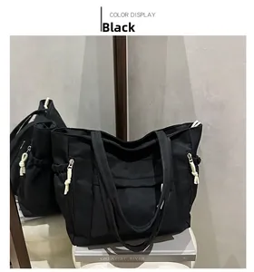 Detail view of large black canvas tote bag with functional multi-pockets and zip pulls