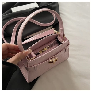 Détail du sac rose clair motif crocodile avec fermoir doré et poche intérieure zippée