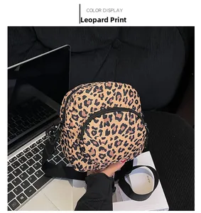 Close-up of leopard print crossbody bag on a black sofa with lifestyle accessories