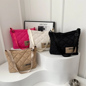 Sac fourre-tout matelassé minimaliste en quatre couleurs sur un présentoir blanc