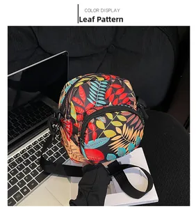 Detail of multi-colored leaf pattern nylon crossbody bag on a textured surface