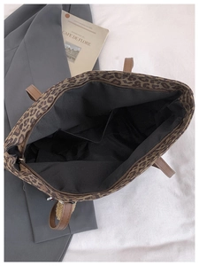 Detailed interior of leopard print tote bag showing zipper closure and large inner pocket