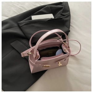 Vue intérieure du sac rose motif crocodile montrant la doublure verte et la poche zippée