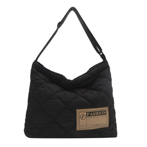 Black quilted tote bag with diamond pattern and adjustable strap for daily commute