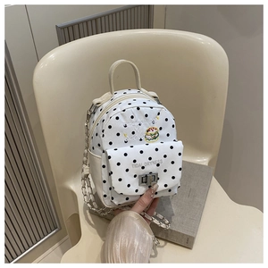 Close-up of polka dot canvas backpack with burger embroidery and metal chain strap
