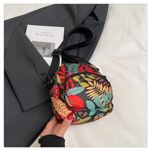 Detailed close-up of a mini canvas crossbody bag with colorful tropical leaf prints