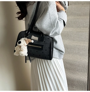 Close-up of canvas polka dot shoulder bag with cute plush puppy charm detail