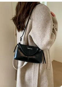 Detail der schwarzen glänzenden PU-Ledertasche mit Quasten-Kordelzug und Label