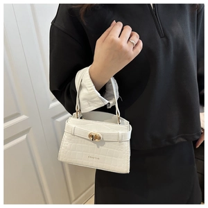 Détail rapproché de la texture cuir croco blanc avec fermoir tournant doré élégant