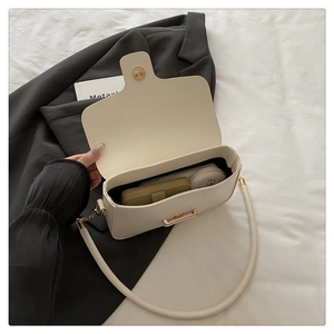 Interior view showing the large capacity of a cream leather crossbody bag with items