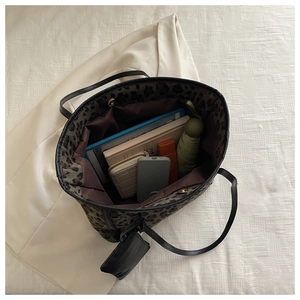 Macro interior view of leopard print tote bag showing large storage capacity and inner pouch