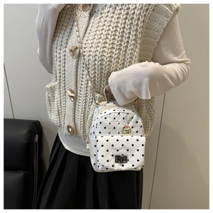 Gros plan du mini sac à dos blanc à pois avec bandoulière chaîne et broderie burger