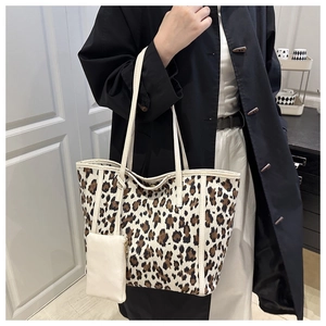 Detail of leopard print tote bag featuring a white strap and matching detachable coin purse