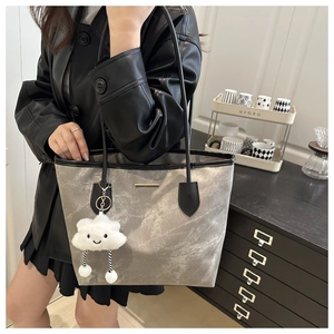 Detail of silver marble tote bag with black leather handle and plush cloud charm