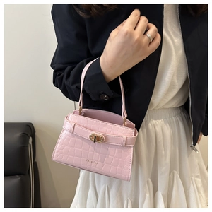 Détail du mini sac à main rose gaufré crocodile avec boucle dorée et fermeture élégante